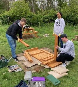 people assembling a picnic table